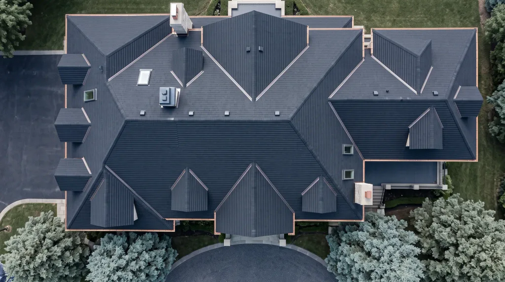 Overhead drone view of a large asphalt-shingle roof and its valleys